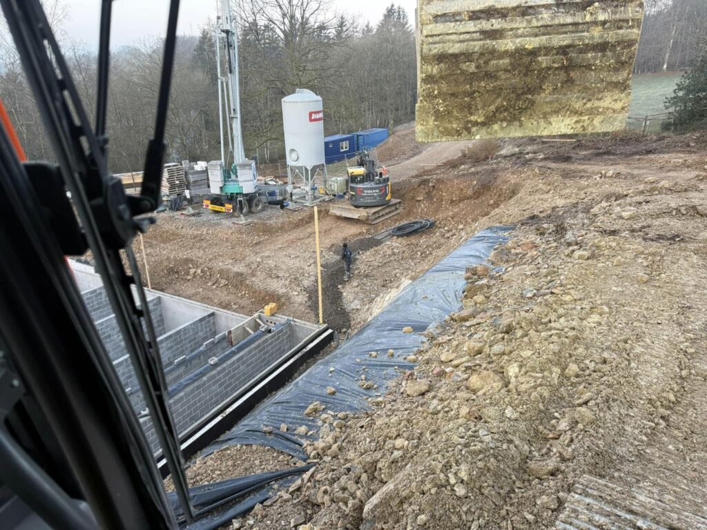 Travaux de terrassement à Waimes sur chantier en pente avec préparation du sol et mise en place de géotextile